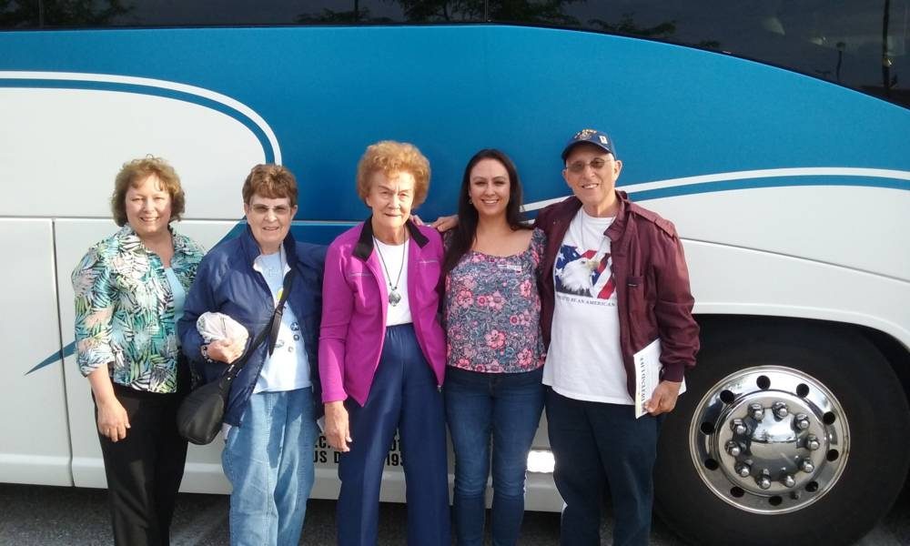 A family posed in front of a Rill's motorcoach